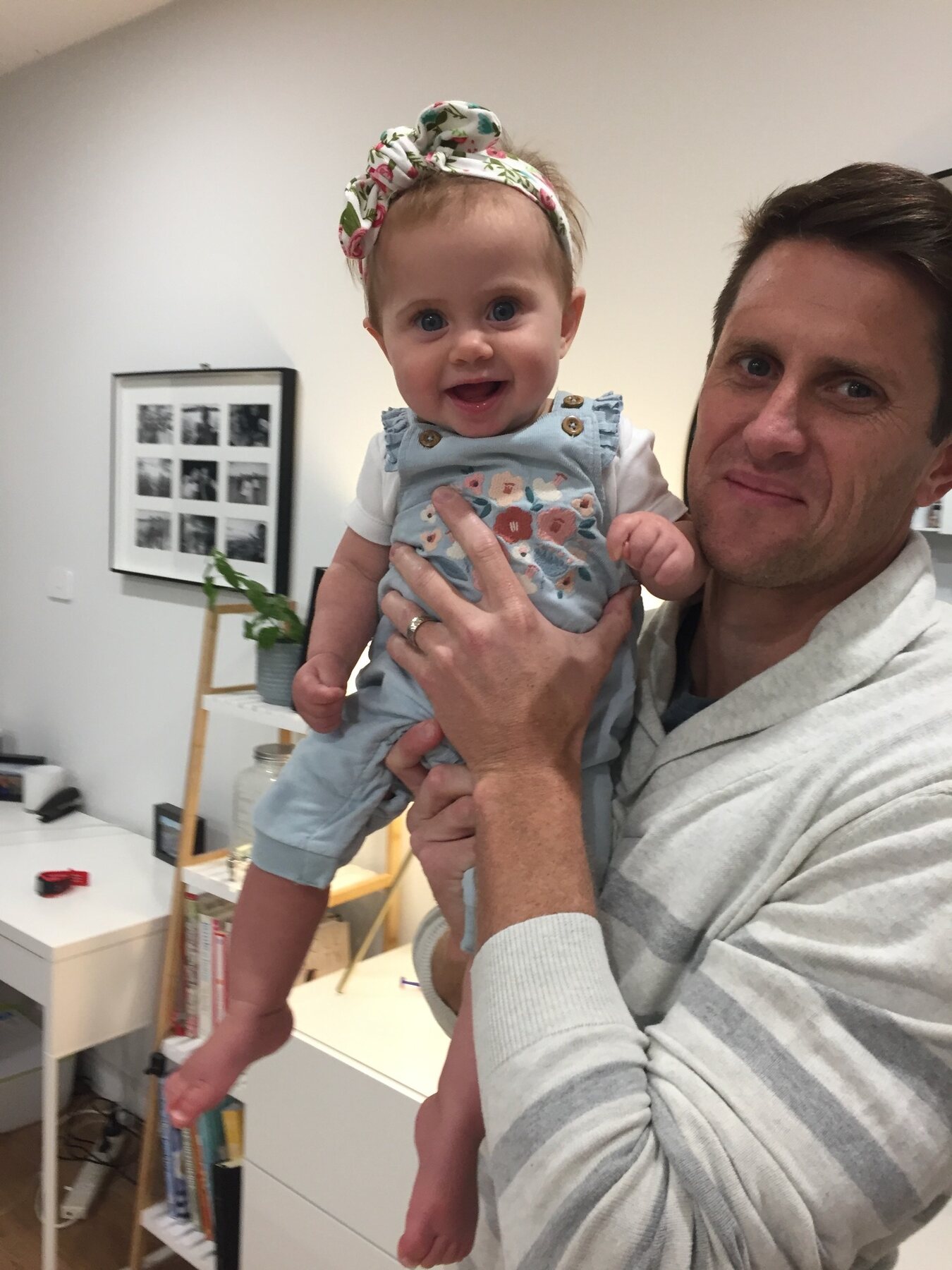 Baby Flo smiling while being held by her dad