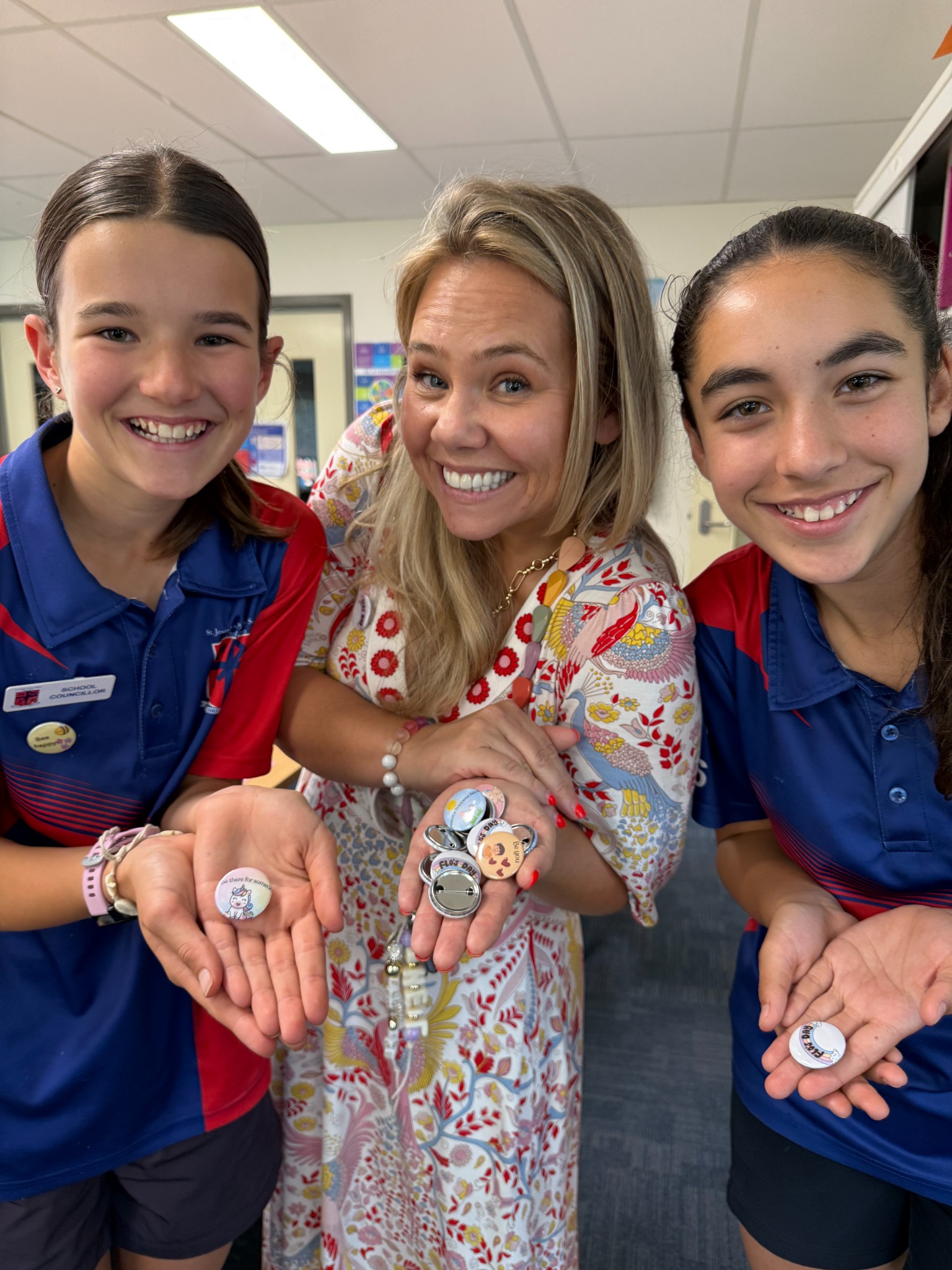Michelle and two Flo’s Day young creators proudly showing the badges they made